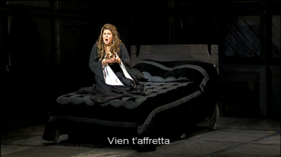 Lady Macbeth (Maria Guleghina), al llit, cantant l'ària «Vieni t'affretta».